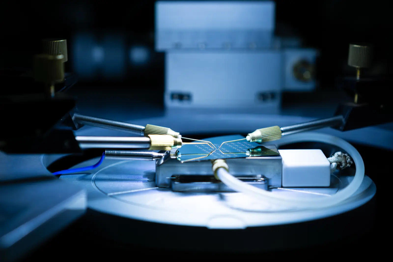 Probe station in the lab, with four probe tips resting on a device chip